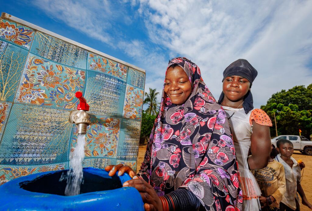 Mulheres coletando água do abastecimento de água