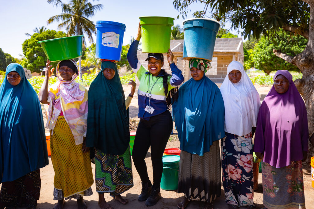 Pessoas locais carregando água na cabeça da fonte de abastecimento.